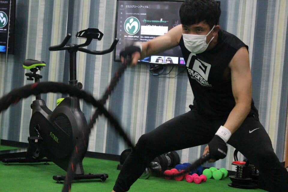 トレーニング器具で筋トレをするトレーナー